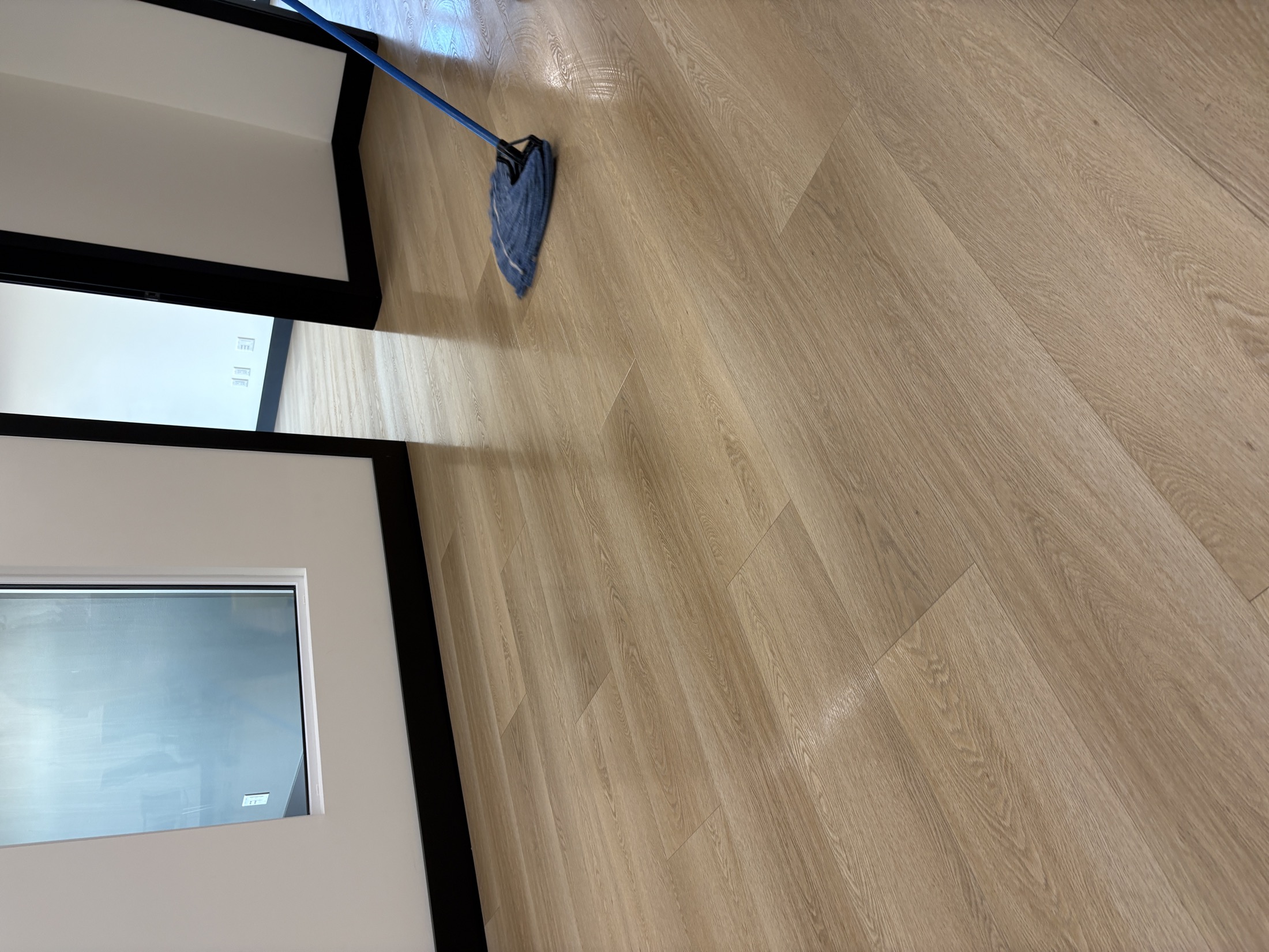 A freshly mopped, gleaming wood-grain floor in a bright office