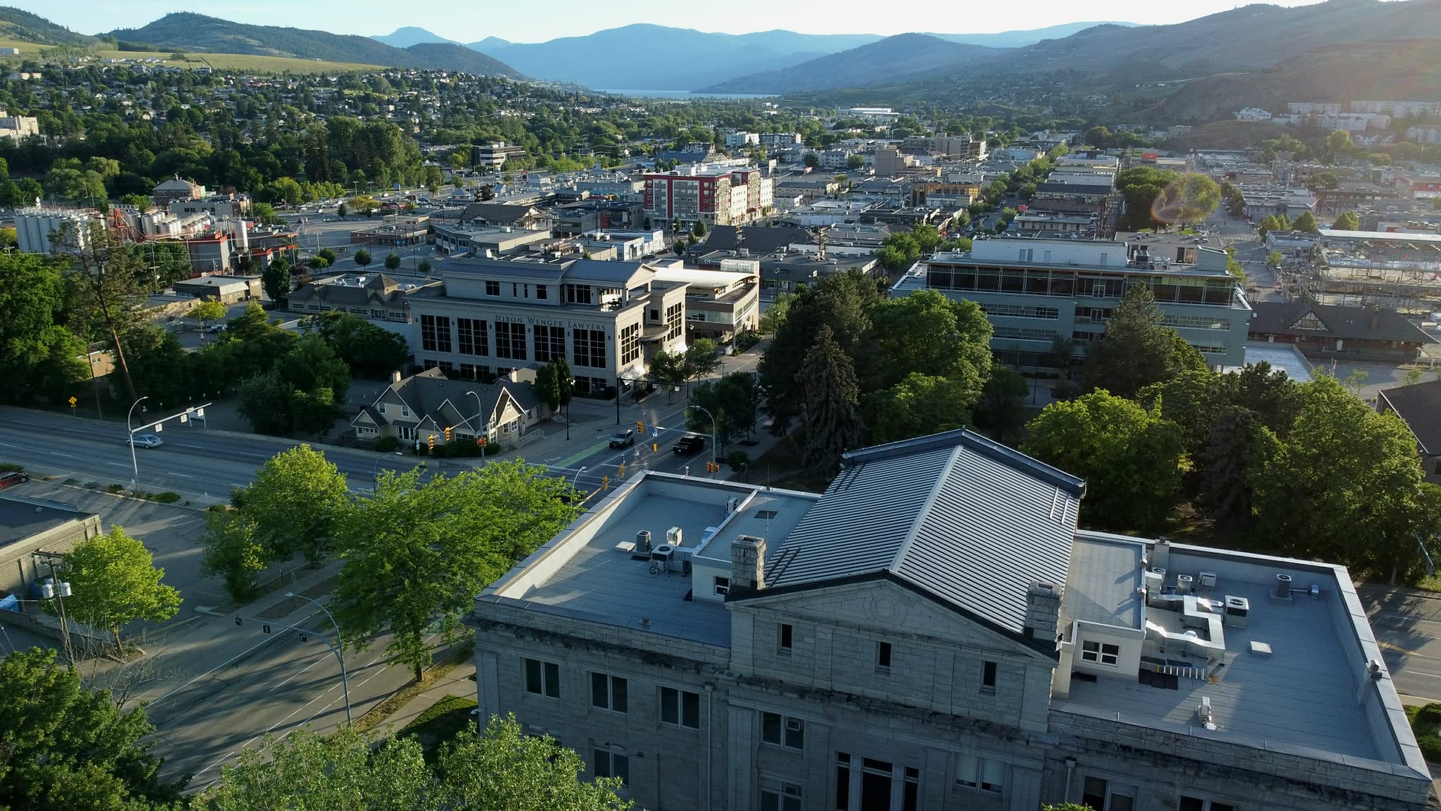 Elevated view of downtown Vernon, BC in warm evening light, with the North Okanagan hills beyond